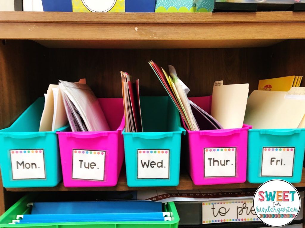 Colorful classroom organization bins labeled with the days of the week.