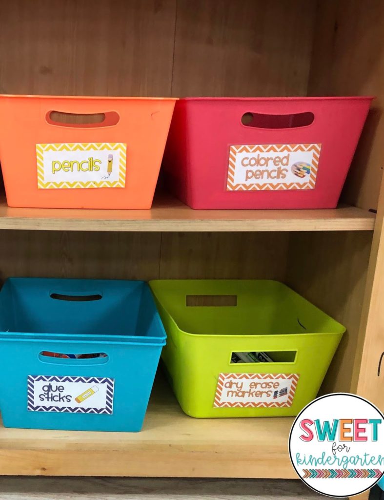 Photo of four bins labeled Pencils, Colored Pencils, Glue Sticks, and Dry Erase Markers for teachers working on classroom organization.
